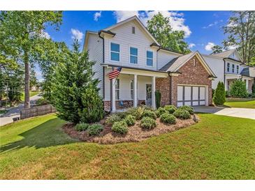 Two-story brick and white home with landscaped yard and attached garage at 253 N Gwinnett St, Buford, GA 30518