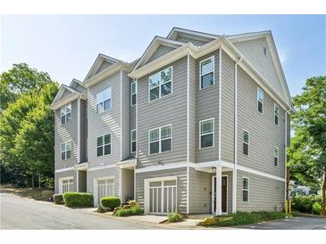 Three-story townhome with gray siding, attached garage, and landscaping at 1365 Memorial Se Dr # 3, Atlanta, GA 30317