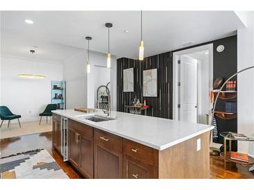 Modern kitchen island with white countertops and wood cabinets at 3630 Peachtree Ne Rd # 2005, Atlanta, GA 30326