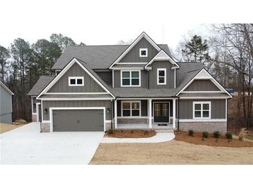 Charming two-story home featuring gray siding, a covered front porch, and an attached two-car garage at 1037 Hawthorn Ct, Loganville, GA 30052