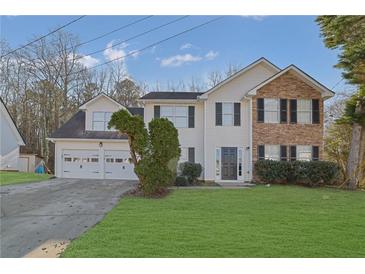 Charming two-story home with a manicured lawn, a two-car garage, and a stone and vinyl facade at 2295 Creekview Trl, Decatur, GA 30035