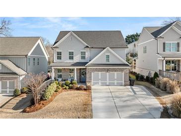 Two-story home with gray siding, brick accents, and a three-car garage at 91 Harris St, Buford, GA 30518