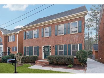 Brick two-story house with green shutters, landscaping, and driveway at 3182 Henderson Walk, Atlanta, GA 30340