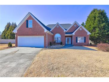 Brick house with a two-car garage and well-manicured lawn at 216 Chad Ln, Loganville, GA 30052