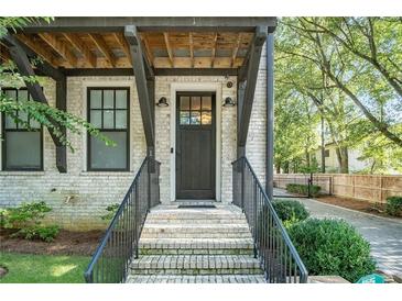 White brick townhome exterior with dark brown front door and steps leading to entrance at 18 Peachtree Ne Ave # 1, Atlanta, GA 30305