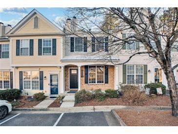 Two story townhome with brick and siding exterior, front porch, and landscaping at 273 Devonshire Dr, Alpharetta, GA 30022