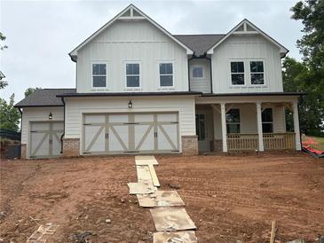 Charming two-story home with white siding, large windows, a two-car garage, and an inviting front porch at 344 Riverwood Pass, Dallas, GA 30157