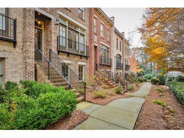 Brick townhouses with a walkway, landscaping, and autumn leaves at 25 High Gate Trl, Decatur, GA 30030