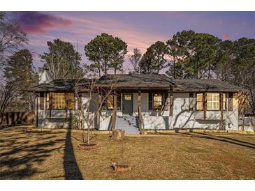 Charming brick ranch house with a spacious lawn and mature trees at 8951 Country Club Dr, Douglasville, GA 30134