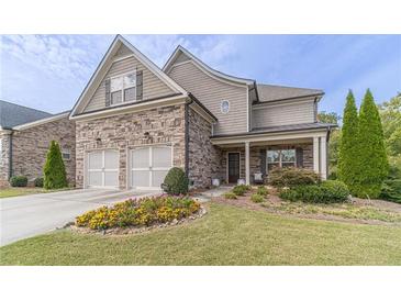 Two-story home with stone and shingle accents, two-car garage, and landscaped front yard at 5960 Overlook Club Cir, Suwanee, GA 30024