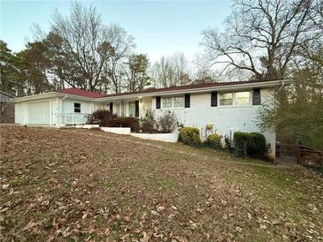 Ranch style home with white brick exterior, red roof and attached garage at 3112 Crestview Cir, Duluth, GA 30096