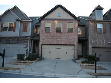 Charming townhome with brick facade, two-car garage, and well-maintained landscaping at 3280 Hallmark Ln, Buford, GA 30519