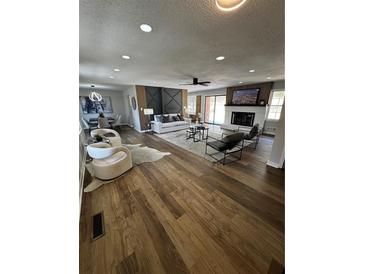 Open-concept living room with modern furnishings, fireplace, and hardwood floors at 3421 Fawn Trl, Marietta, GA 30066