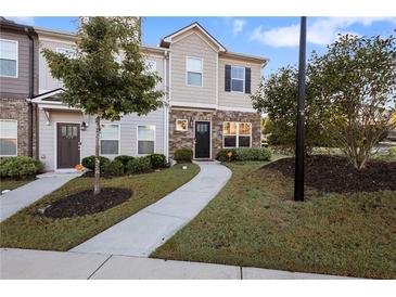 Inviting townhome with stone accents and a landscaped lawn at 921 Ambient Sw Way, Atlanta, GA 30331