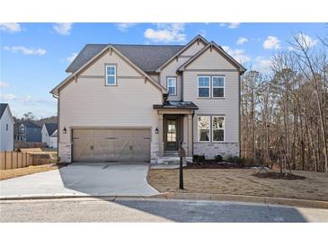 Two-story house with gray siding, stone accents, and a three-car garage at 23 Rockberry Ct, Dallas, GA 30157