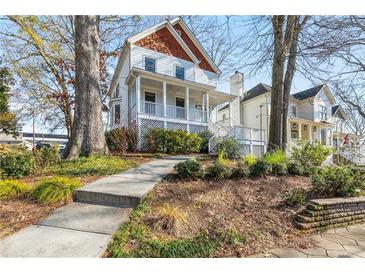 Two-story house with a wrap-around porch and landscaped yard at 1009 Longley Nw Ave, Atlanta, GA 30318