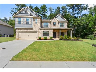 Two story home with gray and brick exterior, landscaped lawn, and attached two-car garage at 2570 Reynolds Sw Rd, Atlanta, GA 30331