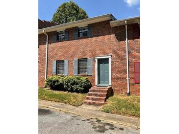 Brick townhouse exterior with landscaping and a teal front door at 6354 Shannon Pkwy # 6D, Union City, GA 30291