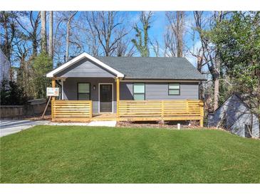 Charming gray home featuring a cozy front porch with wooden railings and a well-manicured green lawn at 2019 Arlington Nw Cir, Atlanta, GA 30318