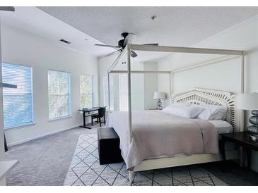 Spacious primary bedroom with a large bed, plenty of natural light, and a ceiling fan at 10 Perimeter Summit Ne Blvd # 1410, Brookhaven, GA 30319