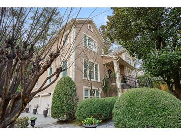 Exterior of charming two-story home with manicured landscaping and three-car garage at 1013 Lenox Valley Ne Dr, Atlanta, GA 30324