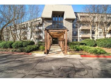 Inviting condo building entrance with stone accents and covered walkway at 1214 Highland Bluff Se Dr # 214, Atlanta, GA 30339