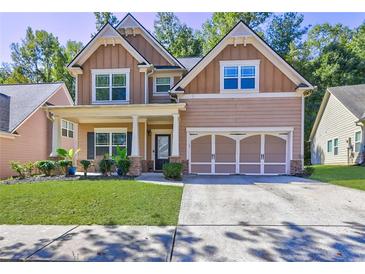 Two-story house with a large front yard, attached garage, and neutral color scheme at 4233 Creekrun Cir, Buford, GA 30519