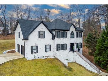 Two-story white brick house with black accents, attached garage, and landscaped yard at 4492 Bryten Dr, Douglasville, GA 30135