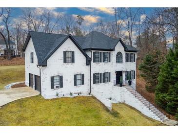 Charming two-story home boasts a classic design with a black roof and shutters and a nicely landscaped front yard at 4492 Bryten Dr, Douglasville, GA 30135