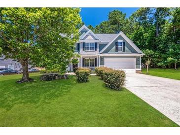 Two-story house with green siding, white trim, and a landscaped lawn at 6196 Windflower Dr, Powder Springs, GA 30127