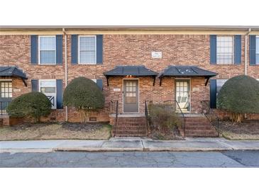 Brick townhouse exterior with landscaping and a walkway at 5667 Kingsport Dr, Atlanta, GA 30342