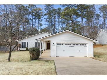 White house with two-car garage and landscaped yard at 670 Lake Forest Ct, Roswell, GA 30076