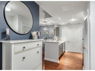 Stylish kitchen with stainless steel appliances, white cabinets, and a view into the living area at 1101 Juniper Ne St # 415, Atlanta, GA 30309