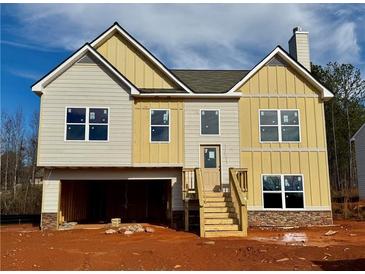 Two-story house with beige and yellow siding, a wooden staircase, and a two-car garage at 478 Charleston Pl, Villa Rica, GA 30180