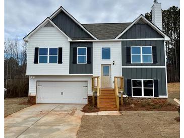 Two-story home with a two-car garage, neutral color palette, black shutters, and wooden steps leading to the front door at 478 Charleston Pl, Villa Rica, GA 30180