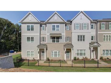 Three-story townhouses with gray siding, black accents, and a fenced yard at 4822 Floydwood Ln, Mableton, GA 30126