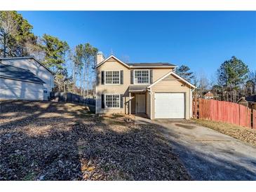 Tan two-story house with attached garage and fenced backyard at 3727 Conley Downs Ln, Decatur, GA 30034