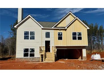 Two-story house with beige and yellow siding, stone accents, and a wooden staircase at 482 Charleston Pl, Villa Rica, GA 30180