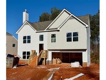 Two-story house with gray and white siding, a two-car garage, and a wooden staircase at 482 Charleston Pl, Villa Rica, GA 30180