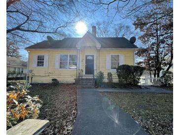 Charming yellow house with front porch and walkway at 1294 N Avenue Nw, Atlanta, GA 30318