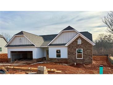 Newly constructed home boasts a charming exterior with stone accents and a two-car garage at 475 Charleston Pl, Villa Rica, GA 30180