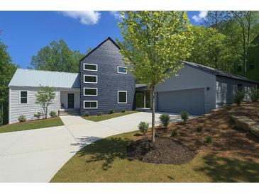 Stunning contemporary home boasts a large driveway, modern architecture, and attached two-car garage at 160 Cedarwood Ln, Roswell, GA 30075