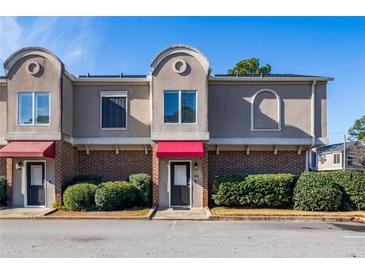 Brick front townhouse with red awning and landscaping at 3301 Henderson Mill Rd # X4, Atlanta, GA 30341