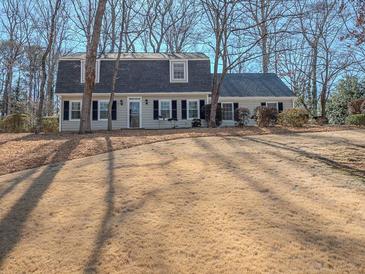 Traditional home featuring a well-manicured lawn and mature trees, creating a serene and inviting outdoor space at 3640 Longfellow Trl, Marietta, GA 30062