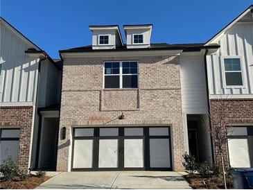 Charming brick townhome featuring dormer windows and an attached two-car garage at 222 Depot Landing Rd # 58, Auburn, GA 30011