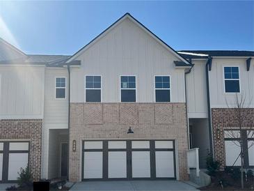 Charming townhome featuring a brick and siding facade, complemented by a convenient two-car garage at 216 Depot Landing Rd # 61, Auburn, GA 30011