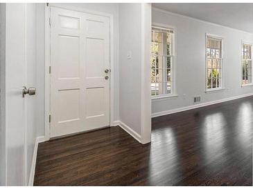 Bright entryway features beautiful dark wood floors and a white front door at 2540 Thornton Dr, Atlanta, GA 30349