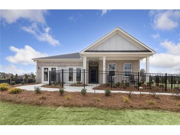 Brick house with a front porch and black metal fence, landscaped yard at 630 Pineberry Ct, Grayson, GA 30017