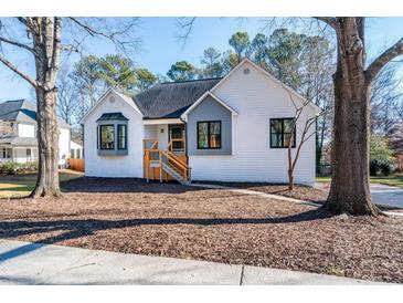 Stunning white modern farmhouse exterior with gray accents and a charming front porch at 3779 Churchill Sw Dr, Marietta, GA 30064