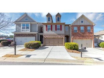 Three-unit townhome community with attached garages and manicured landscaping at 3457 Sardis Bend Dr, Buford, GA 30519